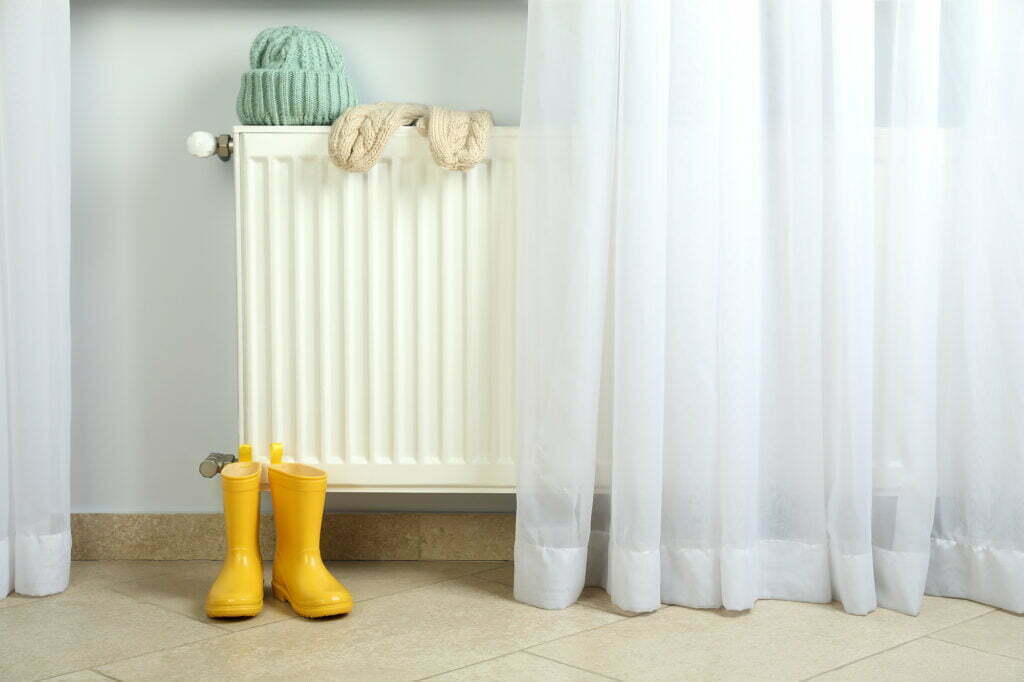 Radiator in a home with winter clothes on top of it